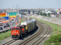 The demolition of the westbound lanes of autoroute 20 in Montreal continues at right as CN 401 heads west towards Taschereau Yard with ES44AC's CN 2990 & CN 2969 for power. In the background is the rapidly changing Turcot interchange.