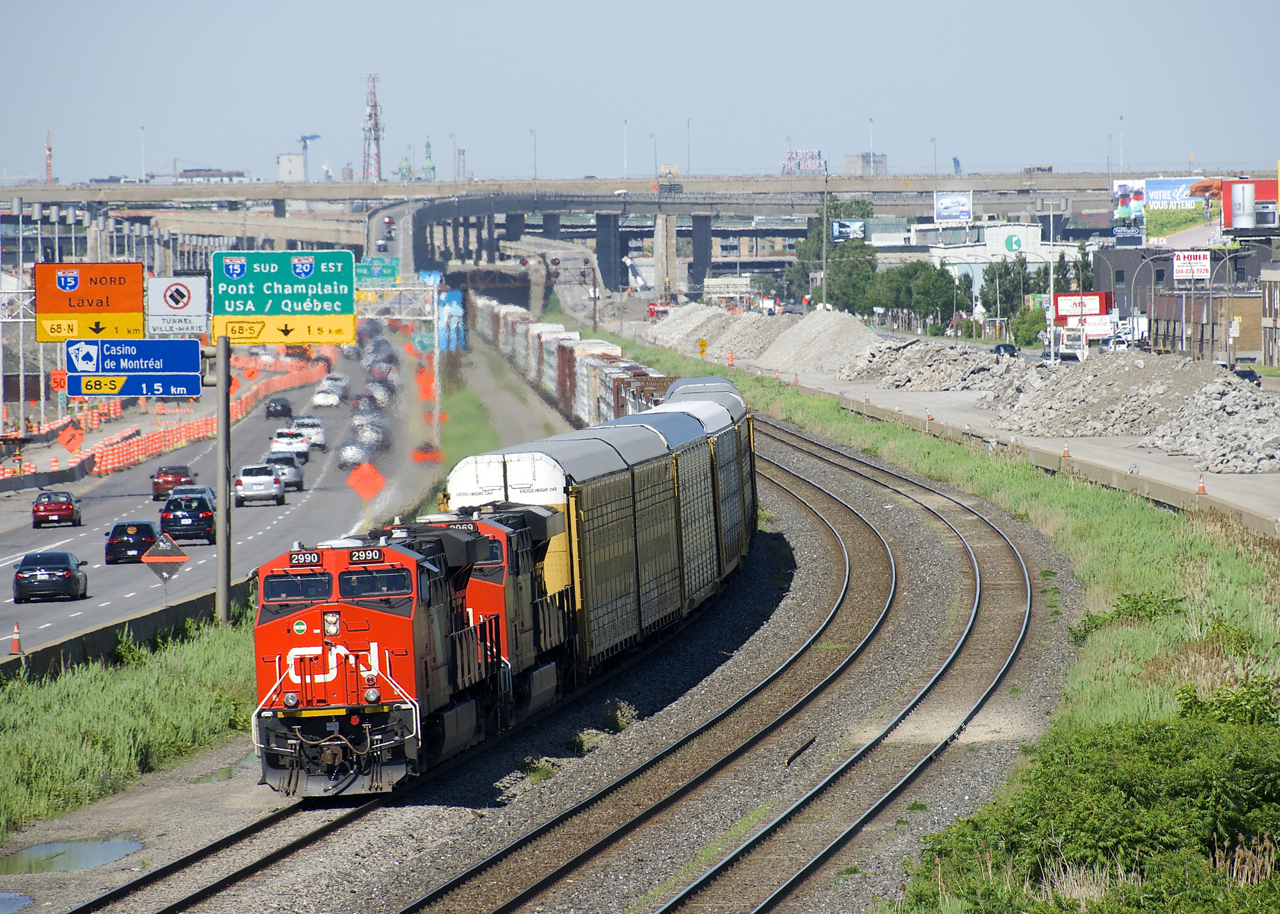 The demolition of the westbound lanes of autoroute 20 in Montreal continues at right as CN 401 heads west towards Taschereau Yard with ES44AC's CN 2990 & CN 2969 for power. In the background is the rapidly changing Turcot interchange.