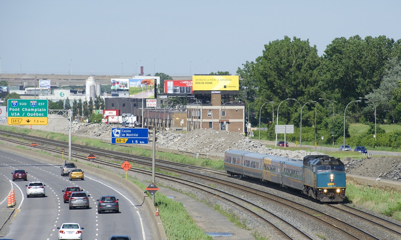 VIA 67 has VIA 6435 leading 4 LRC cars as it passes the eastbound lanes of autoroute 20 at left, with the site of where the westbound lanes were at right.