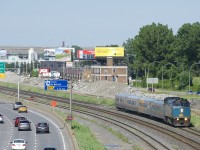 VIA 67 has VIA 6435 leading 4 LRC cars as it passes the eastbound lanes of autoroute 20 at left, with the site of where the westbound lanes were at right.