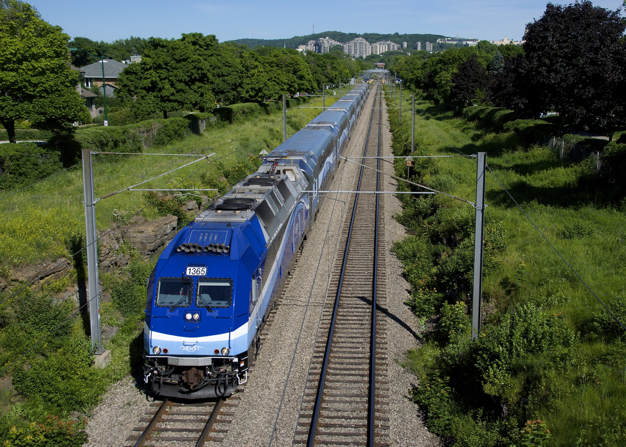 The AMT (later the RTM and just recently rebranded as EXO) bought twenty dual mode ALP45-DP's (able to operate in both diesel-electric and straight electric mode) from Bombardier in 2008, for use on the electrified Deux-Montagnes Sub. Unfortunately these engines have mostly seen use on non-electrified lines, but here AMT 1365 has its pantograph up as it approaches a pedestrian overpass in the Town of Mount Royal. In a few miles (at Ahuntsic Station) the pantograph will go down and this train will continue to Mascouche in diesel-electric mode. Unfortunately a light rail project (the Réseau express métropolitain) will soon replace this heavy rail line and Masouche-line trains will not be able to operate straight into Montreal's Central Station, with commuters forced to switch trains.