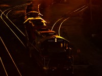 <b>This Wheel's on Fire.</b>
A trio of EMDs work CN's Stuart Street Yard as the sun sinks below the horizon in a fiery orange glow.