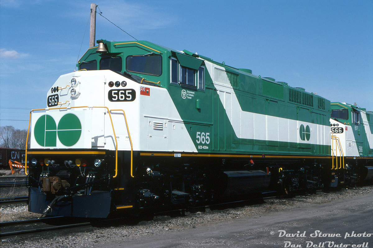 Brand new GO Transit F59PH units 565 & 566 sit at CN's London yard, freshly minted from the nearby GMD London locomotive assembly plant. Units 562-568 were GO Transit's final order of seven F59PH's delivered in 1994 (which GO traded in GP40's 720-726 on them, that became EMDX 200-series leasers). Due to cuts and lower ridership in the mid-late 90's, GO sold off four units (565-568) to Trinity Railway Express, apparently the reason being they'd get more for selling newer units than their older ones. 562-564 remained and continued to operate for GO with the rest of their F59 fleet, and today remain a few of the handful of rebuilt F59's GO still operates.Dave Stowe photo, Kodachrome from the Dan Dell'Unto coll.