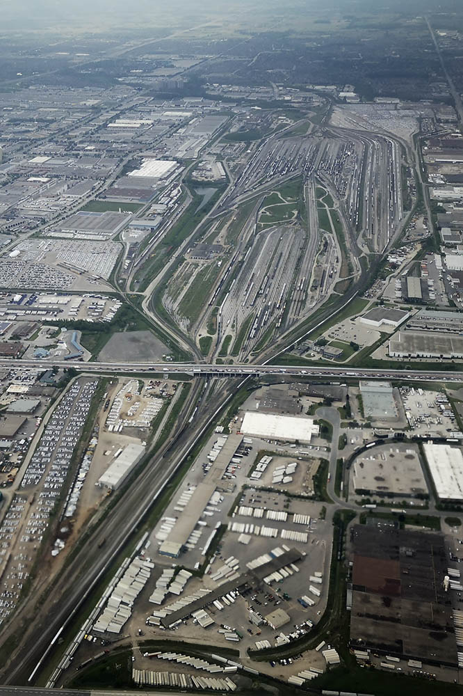An overview of Mac Yard while landing at YYZ. L(Local) yard is the bottom centre and then left to right West Control, C yard ( the receivers for cars coing over the Dual Hump, East Control and  R (Receiving ) is the farthest to the right. The shops are in the top left corner. The Car Repair shop is just left of L yard, but appears to be all but abandoned. It was always full back in the 80's be it repairs, or "cleaners"; box cars in to be cleaned out. In the top right; well that used to be ConPort, which has moved to BIT, so I assume it's now an auto transloading operation.