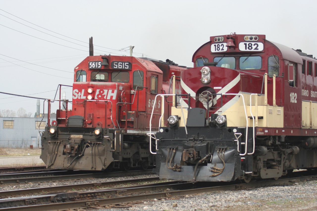 A westbound Canadian Pacific train with STLH SD40-2 5615 blasts by the Woodstock, Ontario station as Ontario Southland Railway RS18u 182 waits to continue it's switching duties.