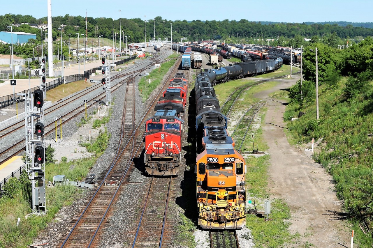 CN 2555 rolls up beside Quebec Gatineau 2500 (SOR) after setting off a few cars in the siding to return to the main track to retrieve the rest of its train.