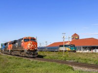 A late CN Q120 passes by the VIA station at Moncton, New Brunswick. Parked near the station is the power and 4 cars for the CN Safety Days passenger train, which will run between CN's Gordon Yard and the VIA station. 