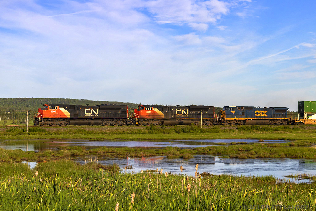 CN 8909 leads stack train Q120, shortly after heading by the signals for Upper Dorchester. Next up, Dorchester, New Brunswick.