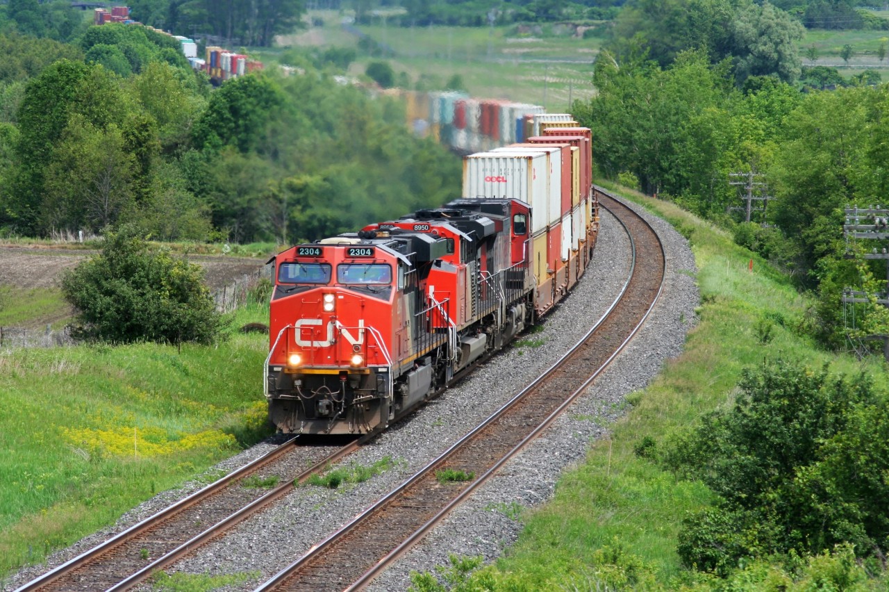 CN ES44DC 2304 leads train 149 through the curves at Newtonville on the Kingston Subdivision on a hot summer afternoon.
