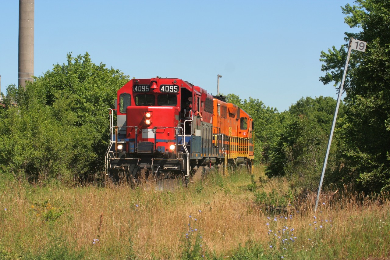 Goderich-Exeter Railway (GEXR) train 518 is traversing the seldom used portion of the Fergus Spur through Preston, Ontario as it heads towards the Babcock & Wilcox facility to lift a massive load. The light power includes; GEXR GP40 4095 and GEXR GP39-2u 2303.