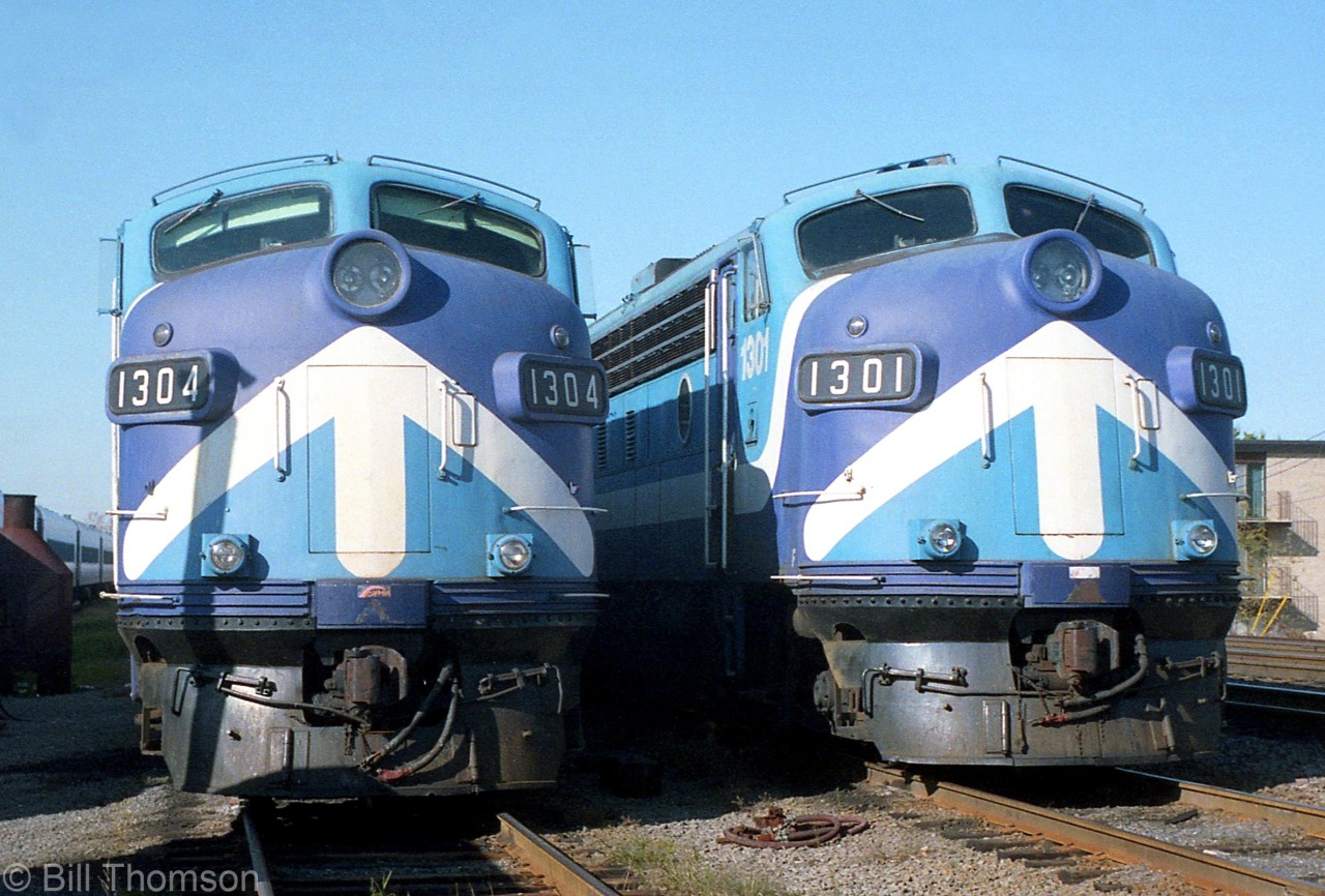 Metropolitan Agence du Transport (MUCTC) FP7's 1304 and 1301 (ex-CP 4074 and 4071) sit side-by-side at the head of commuter trains parked at Dorion QC in 1987. The two units were part of a 7-unit group of long-lived FP7's (4070-4075 and 4040) that CP held onto for commuter service in the Montreal area, which kept racking up the miles long after CP had retired its other units in the early 80's. They all had seen service on The Canadian and The Dominion as 1400's in the 50's and 60's, before being renumbered back to 4000-series units for dual freight/passenger service (often working the Toronto-Sudbury section of The Canadian).

They managed to elude the VIA takeover of most of CP's passenger services in 1978, and eventually these units and the commuter trains they powered ended up going to the MUCTC, STCUM, and eventually AMT where they continued to operate in commuter service until retirement in 2002-2003. The old F's were then sold off, some changing hands a few times and others eventually being scrapped. 1301 still operates on the Durbin and Greenbrier Valley Railway in the US painted up as Western Maryland 243, and 1304 (and 1306) are currently owned by Silcott Railway Equipment (GSLX).