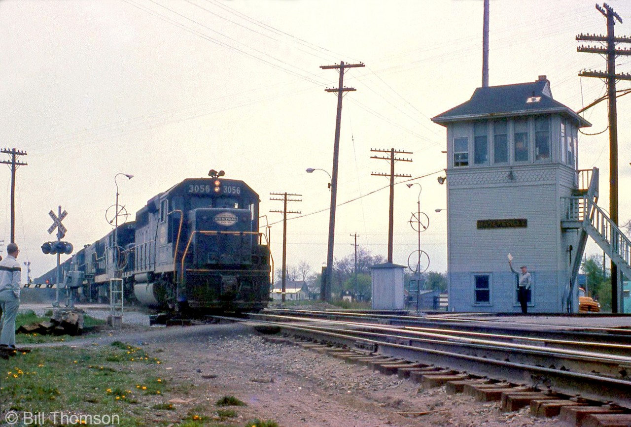 New York Central GP40 3056 leads GE U-boats on a freight past the Hagersville interlocking tower, heading eastbound on the CASO crossing the diamond with the CN Hagersville Sub in the evening.