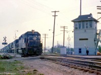 New York Central GP40 3056 leads GE U-boats on a freight past the Hagersville interlocking tower, heading eastbound on the CASO crossing the diamond with the CN Hagersville Sub in the evening.