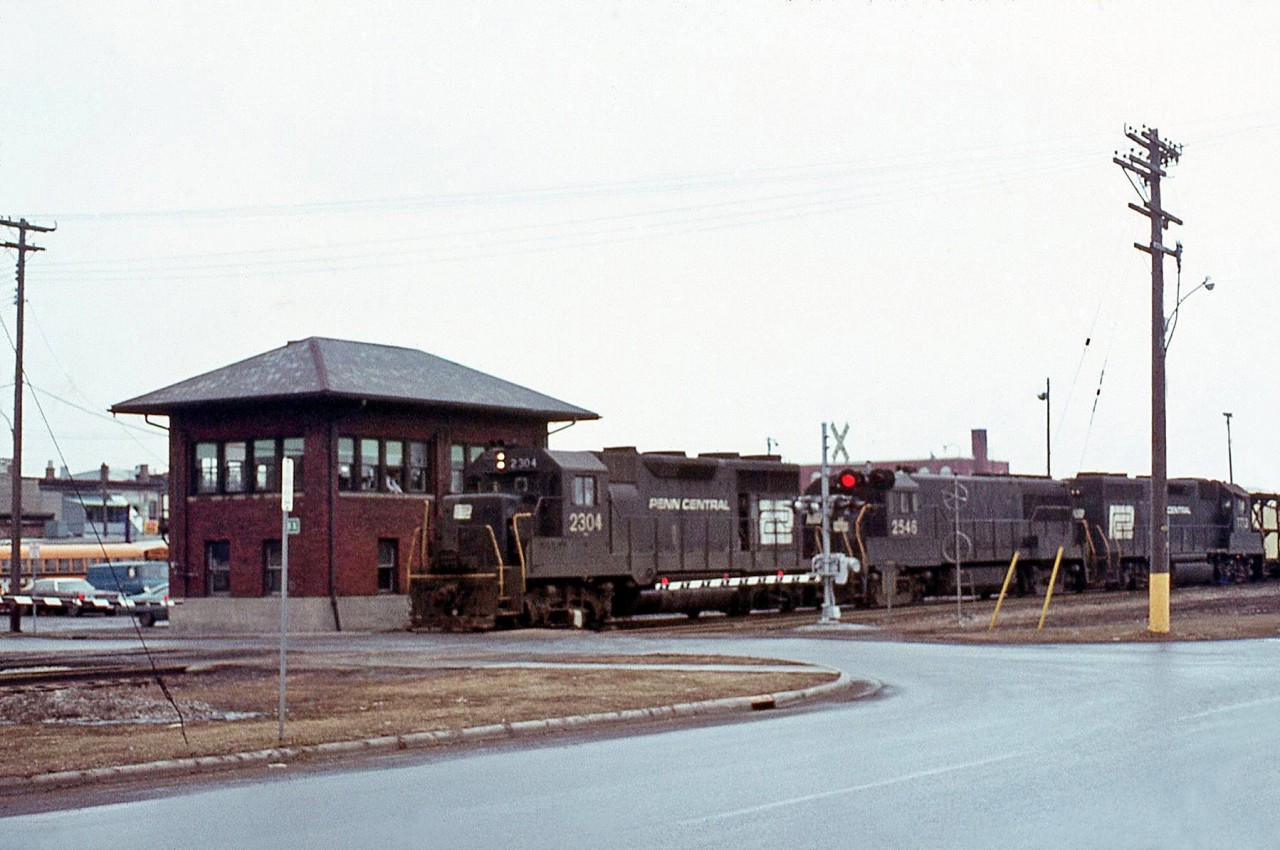 A westbound Penn Central freight passes the old BX Tower on the CASO Sub in St. Thomas. Power up front is GP35 2304, U25B 2548, and a GP38.