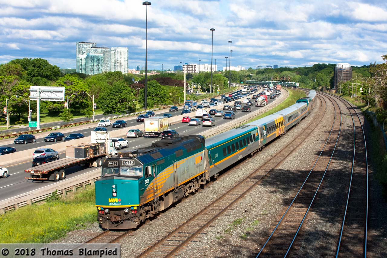 The morning rush hour on the Gardiner is winding down as the equipment for Montreal and Ottawa-bound J train 52 and 62 speeds past the Sunnyside footbridge on its way to Union Station.