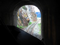 North portal of a short tunnel at mile 125.6 on the BC Rail Squamish sub as we exit north bound. There was a 15 mph speed restriction here account track curvature and severe terrain. Immediately after exiting the tunnel we were onto a "dry slide" and track with a 10 mph permanent slow order "until track seen to be clear", perched on a rock ledge on the shore of Anderson Lake. Beautiful scenery but treacherous terrain for a railroad.