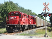 <B>CP 3117</B> is westbound with 20 cars for West Coke siding as it approaches Oxford Rd 4 near Innerkip.  Station name sign PENDER one mile can be seen to the right of the crossbucks. 