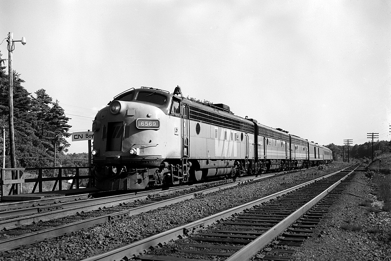 Northbound #9 stops for a crew change at CN Boyne, situated along James Bay Jct Rd (North) off old Hwy 69 about 5 KM south of Parry Sound itself. It is later in the afternoon but the light is still good here, so I elected to go with B/W 400 ISO sheet film in the 4x5 Speed Graphic. Shot at 200f11 on account train is stopped and I would not end up with motion blur.  Power is 6569, 6625 and 66xx........missed the last number. The 6569 upon becoming part of CP's contribution to VIA, was CP 1425 and originally #4069. According to CTG it is now with the West Coast Railway Association as their 4069.