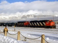 CN SD60F 5509 and SD40-2W 5241 are seen arriving on a westbound freight at Jasper, with the snow-covered mountain ranges and a cloudy white/blue sky making for a very picturesque scene.