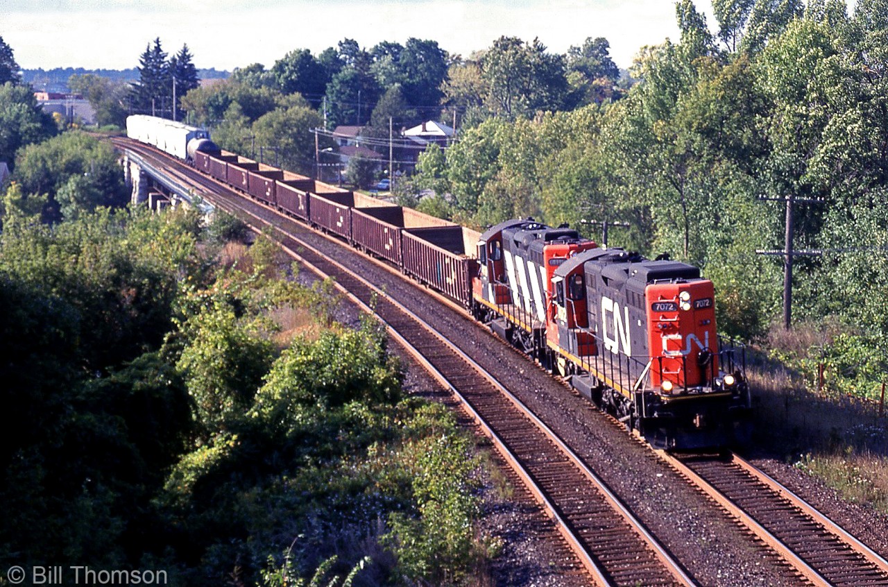 A pair of CN GP9RM's lead by 7072 have just crossed the Napanee Viaduct, heading eastbound at Mile 198.7 of the Kingston Sub with a short train.