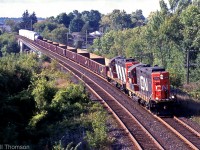 A pair of CN GP9RM's lead by 7072 have just crossed the Napanee Viaduct, heading eastbound at Mile 198.7 of the Kingston Sub with a short train.
