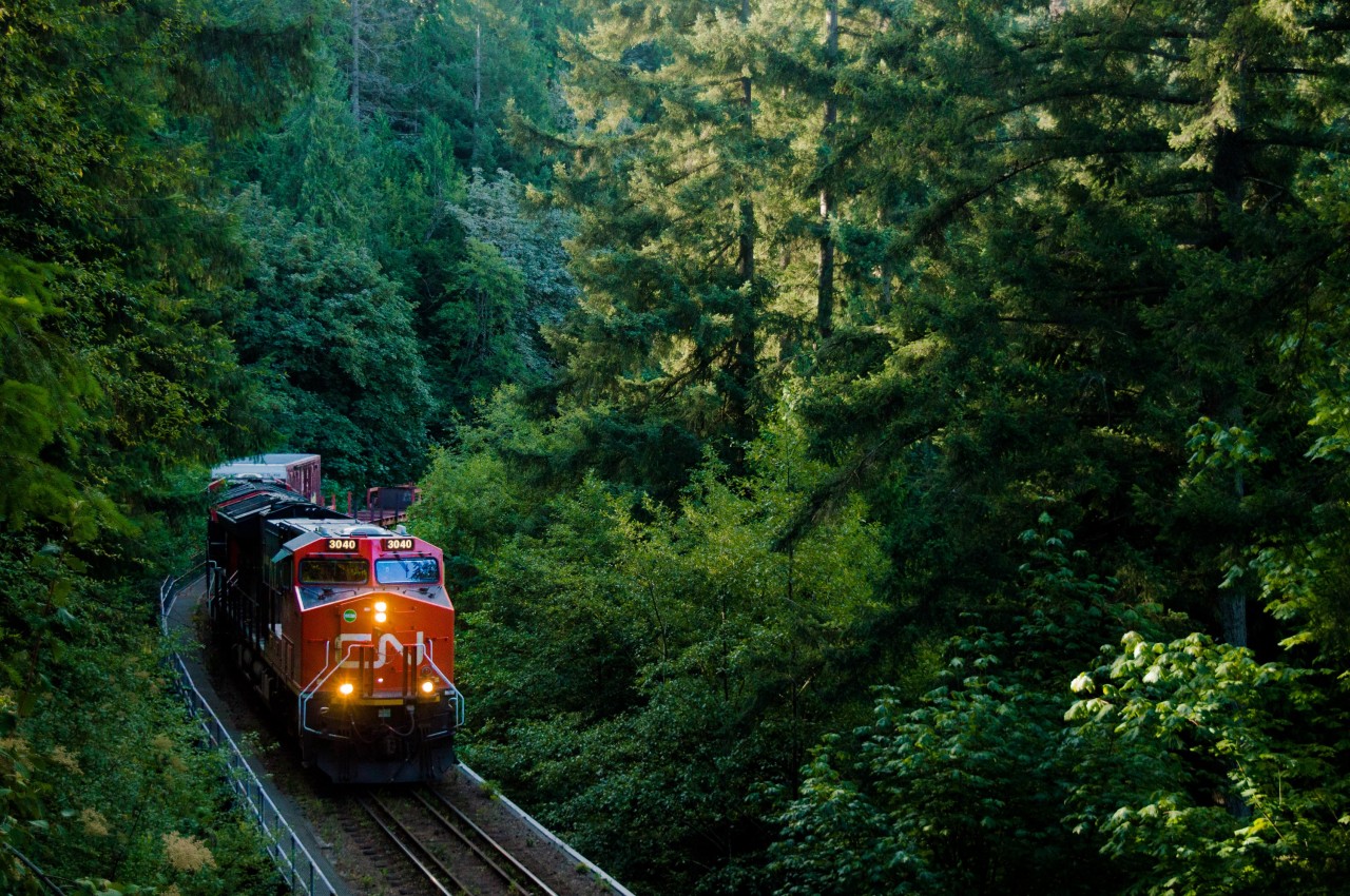 Two Tier 4s make light work of a 26 car L546, rolling towards Squamish through the backyards of West Vancouver and over Wood Creek bridge at Mile 10.

In the old days, location used to have a wood trestle which made quite the photo, but now with the forest growing in it's hard to even notice the concrete replacement!