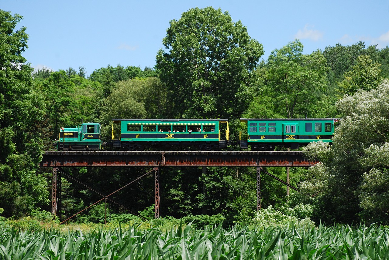 The 2:30 p.m. Port Stanley Terminal Rail train slowly trundles across the steel girder bridge over a small creek just north of Roberts Line.  The boys and I rode the 11:00 a.m. train and I noticed that Roberts Line, after crossing the PSTR curved and there was an opening in the tree line that may make a decent photo angle of the train crossing the bridge.  We happened to be leaving Port Stanley at 2:30 p.m. so we scoped out the location and I'm satisfied with the result.  I hope the lady on the train taking a photo of us is just as satisfied with her photo...