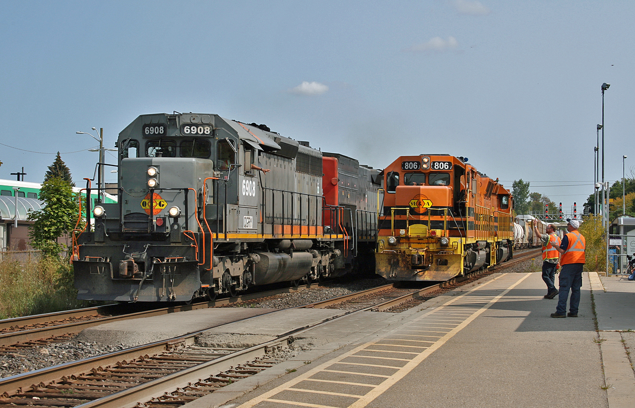 The crew on GEXR 431 exchanges waves with the crew of GEXR 582 on the platform at Georgetown.  582 had just interchanged a D9R dimensional with CN and being a light power move, was held to follow VIA 85 and 431 onto the Guelph Sub.  Power on both trains exemplifies the diversity the Genesee & Wyoming brought to the GEXR with Quebec Gatineau Railway 6908 and GEXR 3054 on train 431; while 582 featured St. Lawrence & Atlantic power with slug 806 and and powered unit 3806