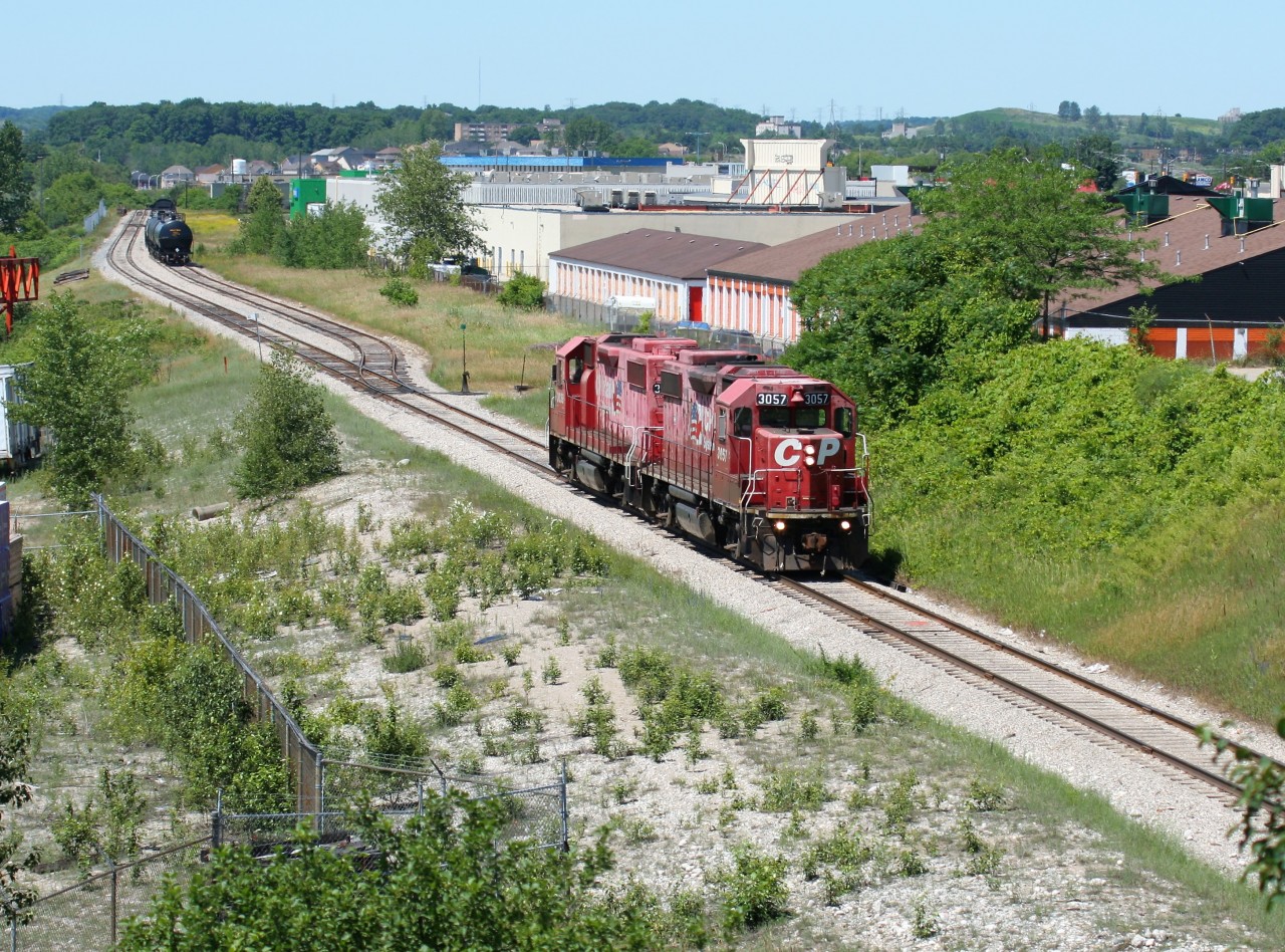Light power, Canadian Pacific GP38-2’s 3057 and 3038, both still in their duel flags paint scheme, are seen returning to Galt, Ontario as they pass Mile 10 on the Waterloo Subdivision in Kitchener, Ontario. The crew has just set-off traffic with the Goderich-Exeter Railway (GEXR) at Kitchener at the interchange between the two companies.