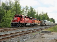 Once in a while having an eastbound running  late, (6:15 pm),  is a good thing. The bright sunshine during the day was making way for rain and a very helpful cloud gave me a chance to get this shot. CP 5023 leads BNSF 8107 and CSX 346 off the Galt sub main and on to the South track as they enter Guelph Junction with 6600 feet of auto racks. 