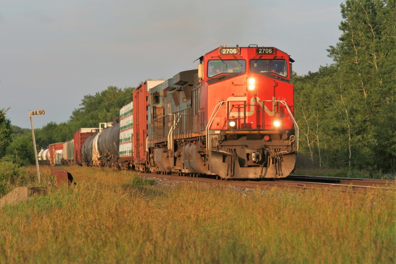 IC C44-9W 2705 and a Blue Devil Dash 8 lead a westbound train at Mile 44 as it approaches the Blain crossovers east of Woodstock, Ontario on CN’s Dundas Subdivision.
