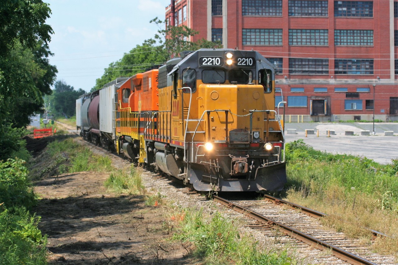 LLPX GP38AC 2210 and Goderich-Exeter Railway (GEXR) GP39-2u 2303 have four hoppers well in control as they lead train 518 into Kitchener from Stratford on a pleasant summer early afternoon.