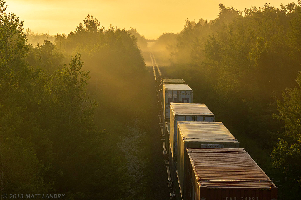 IC 1007 leads train Q120, as they head into the foggy yellow sunset, departing Moncton, New Brunswick.