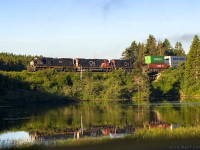 IC 1007 is in charge of eastbound stack train Q120, as they head by Palmers Pond at Dorchester, New Brunswick, near sunrise. 
