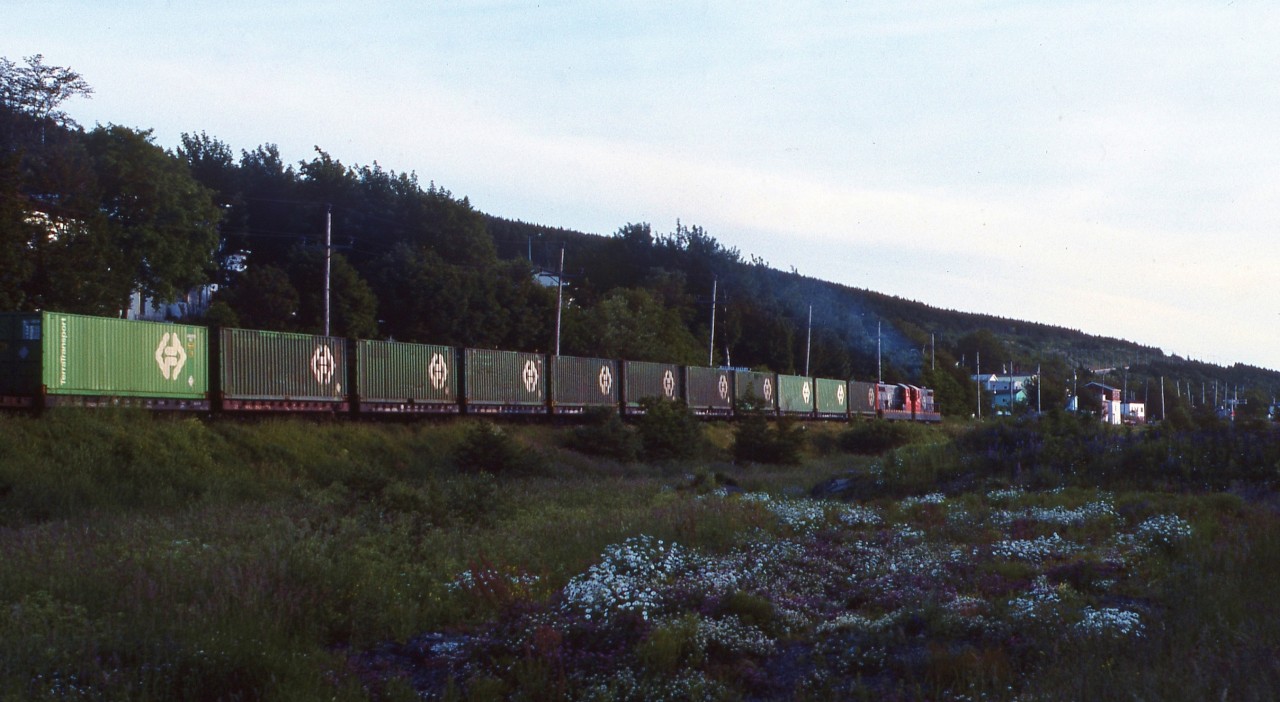 TERRA TRANSPORT TWILIGHT. Twilight has fallen in more ways than one on TerraTransport Extra 919 West as the narrow gauge freight heads westward through the scenic Waterford Valley of St. John's. Not only is the sun setting on this all container train but also the entire operation of the Newfoundland Railway. In less than three months, this MBS train and all that followed it on the 547 mile mainline would cease to run after September 30, 1988. Thirty years ago, when this this scene was captured, photographers such as myself were filled with a sense of sadness, knowing that they were witnessing something that would be lost forever.