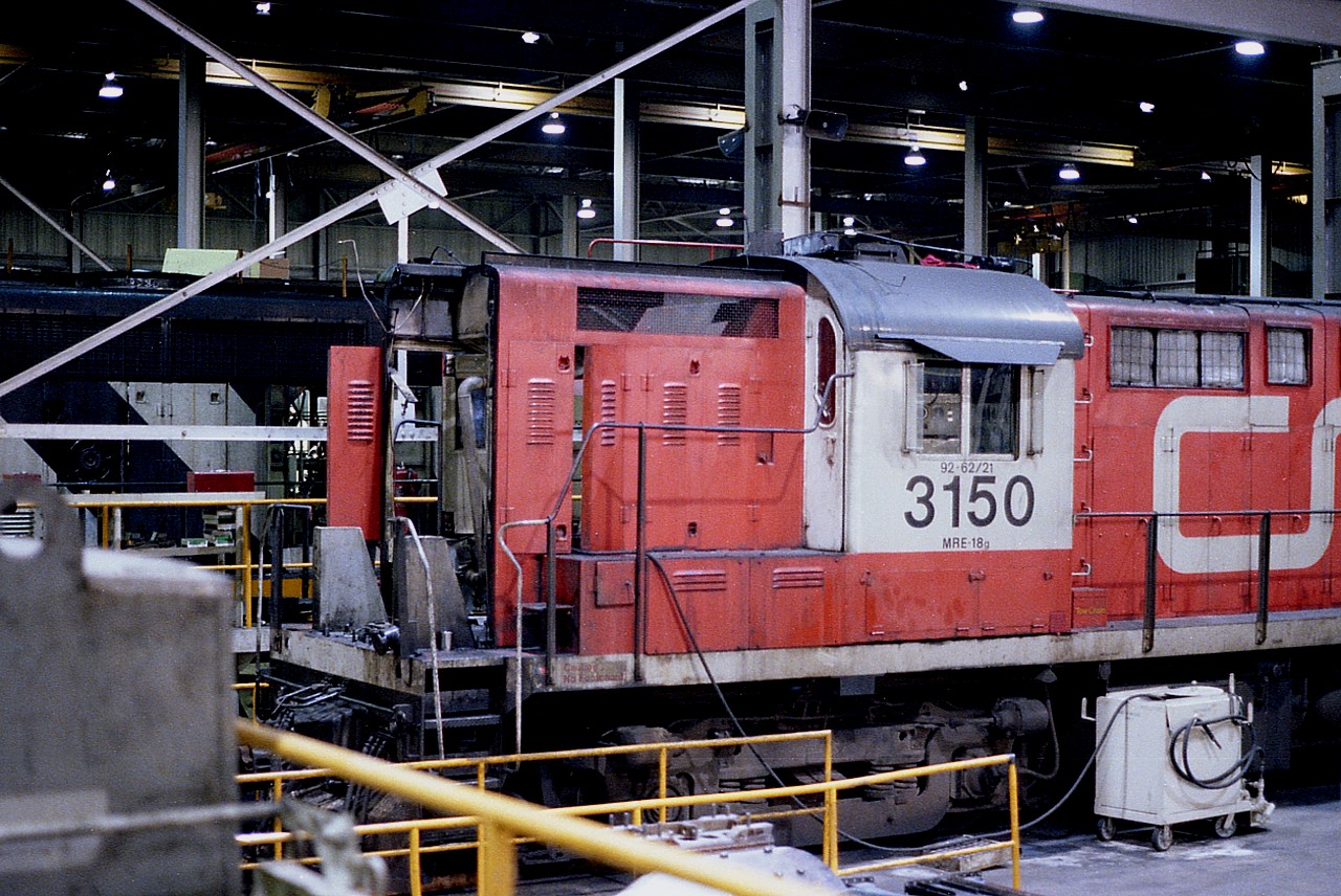Inside the shop at the sprawling CN Macmillan yard north of Toronto we see CN 3150 undergoing work. Hard place to photograph in back then, and not easy for a non-employee to wander around in either. This locomotive, an MLW RS-18m built for "Tempo" passenger service back in 1960, was retired along with its sisters 3151-3155 in 1983.