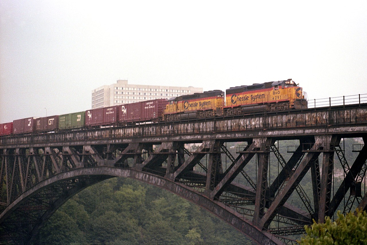 Awh....those long days of summer...the sun is setting a little earlier than it did in June so my best bet when I am getting nervous about when the evening train will be arriving in Canada from Western NY was to head down along the Parkway and watch for it to clear the US customs. Time is of the essence when the sun is sinking to the horizon. Pity we can no longer see trains on a structure such as this; that all ended in the early 200s and the bridge still sits there, forlorn. The estimate back at the time to dismantle this edifice was in excess of 26 million dollars. Enough that the decision was made to just let it rust.  Power on the train tonight is B&O 4291 and  C&O 4173.