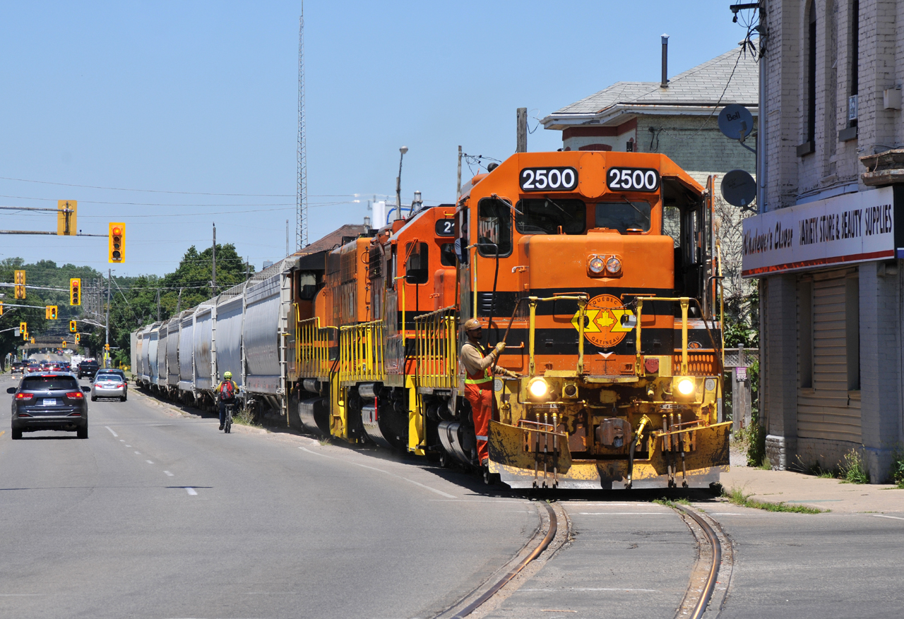 598 trudging their way through downtown Brantford with QGRY 2500, RLHH 2111, RLHH 3049, and 10 hoppers