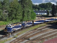 Halted at the end of a reverse move from Rocky Mountaineer Railtour's Vancouver station to wye their train, ex-CN GP40-2W RMRX 8014 leads the June 25th departure with rebuilt GP40-2 RMRX 8019 (origin Penn Central). This long train includes HEP coaches at both ends, and RMR's silver and gold class coach accommodations for both a CN and a CP route tour.  Similarly to VIA, CN, and CP, RMR follows CN/CP directional running in the Fraser Canyon as far as Kamloops.  At Kamloops RMR splits their eastbound trains into CN and CP sections. Westbound RMR trains arriving from CN and CP routes are merged at Kamloops for the trip to Vancouver. <br><br>
Switches at Burrard Inlet Junction (a.k.a. the Diamond) have been set so that the train can proceed forward on the CN/BNSF New Westminster subdivision. <br><br>
The Rocky Mountaineer Railtours station is on the north side of CN's downtown rail yard.  It was built within the shell of a former locomotive maintenance building that once serviced CN Passenger trains. Before RMR's current station site was renovated for their needs, their trains used Pacific Central station. 