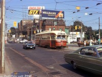 The intersection of Queen Street, King Street, Roncesvalles Avenue and The Queensway in the Sunnyside neighbourhood of Toronto has long been a busy intersection for streetcar traffic, mostly due to the convergance of multiple streetcar routes but also in part due to its proximity to the TTC's Roncesvalles Carhouse a stone's throw away. 
<br><br>
Here on a warm late afternoon summer's day TTC PCC 4455 (an A7-class car bought new in 1947) heads westbound in traffic, rattling across the diamonds and connecting tracks for Roncesvalles-King and crossing from Queen onto The Queenway enroute to Humber Loop. Waiting passengers occupy the stop island in the middle of the road, waiting for the next eastbound Queen car to arrive. The photographer is standing on the sidewalk next to the old Gray Coach Lines Sunnyside bus terminal, and the usual assortment of late 60's/early 70's automotive iron is present (including that rather nice dark blue Mustang). Air conditioning may have been an optional extra in cars of that era, but for most TTC transit vehicles back then (including their fleet of PCC streetcars) the de-facto method of A/C was still propping the window next to you open and enjoying the breeze with your elbow sticking out.
<br><br>
<i>Original photographer unknown (possibly a Dennis Cowley slide), Dan Dell'Unto collection with some colour correction/touch-ups.</i>
