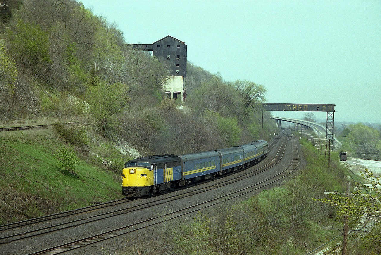 It is a beautiful sunny afternoon in early May, the foliage is just beginning to bring that soft colour to the land. It is a Wednesday afternoon, usually a day I took away from work in lieu of Saturday; and I have made it to a spot I enjoy in order to capture VIA 6771 rolling west past the sprawling remains of the Canada Crushed Stone Ltd complex on the escarpment at about Mile 4, Dundas Sub. This is all gone today, only remains is some hiking trail over old track bed. In the background is Sydenham Rd bridge.