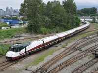 Amtrak Cascades train 519 is seen departing from track leading to Vancouver's Pacific Central Station, with Talgo Pendular Series 8 coachset "Mt Bachelor" and its integrated Control Cab/HEP leading - temporarily.    Scheduled to depart at 5:45 PM, it was passing here at 6:30 PM within a mile of the platform. <br><br>
Most fans consider that the integrated Talgo Control Cab/HEP is NOT one of the better-looking objects intended to lead a train.  I've heard it compared to the face of Donald Duck, or a snail without its shell.  Talgo coach sections are designed low-slung for cornering performance.  A higher cab floor level was required by the 2 axle lead truck, plus having the cab higher than the roof-line of the coaches improves visibility.  (Only place I've seen more than 1 axle in a Talgo coachset).  The unit number is hard to read, low-contrast black digits near the back of the brown swoosh. There are no illuminated number boards, which is rare. <br><br>
On this occasion the delayed departure was because of insurmountable technical difficulties with driving the train from the Control Cab. The solution was to wye the train using the CN / Rocky Mountaineer downtown yard.  Siemens SC-44 "Charger" locomotive AMTK 1403 will be in the lead when they enter the BNSF/CN New Westminster sub at CN Junction after freight movements had cleared.  The control cab has both headlights and red tail lights illuminated, which seems abnormal. 
