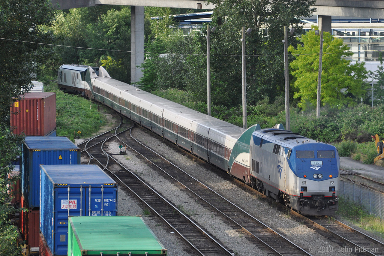 Amtrak Cascades train 517, the 6:35am departure from Vancouver BC's Pacific Central station is approaching the CN/BNSF New Westminster Sub at CN Junction mp 155.3. Its locomotives and Talgo coach-set closely match another Cascades train that fatally derailed at a curve near DuPont in Washington state on 18 December 2017.
In the lead is Siemens SC-44 "Charger" diesel electric locomotive AMTK 1400 with Washington State DOT (WSDOT) and Oregon DOT lettering, and the Mt. Hood Talgo trainset in the Cascades paint scheme. A GE P42DC "Genesis" AMTK 85 in ordinary Amtrak scheme is at the rear (it lead into Vancouver). Note the short articulated sections with single axle wheel sets of the passively-tilting Talgo coach-set. The end transition sections with HEP and baggage compartment were styled to merge with F59PHi locomotives originally purchased for Cascades service.
The bridgework of Vancouver's Millenium Line Skytrain can be seen, it parallels the New Westminster sub for several miles, starting here.
A view of this train from the front:  http://www.railpictures.ca/?attachment_id=34014
