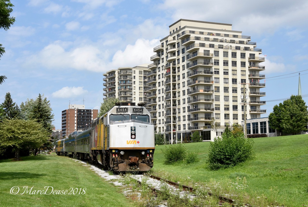 VIA 6454 in 40th Anniversary wrap is dwarfed by the towering sky scrapers of downtown Sarnia as they prepare to head back to the VIA Station after a day of display at Centennial Park.