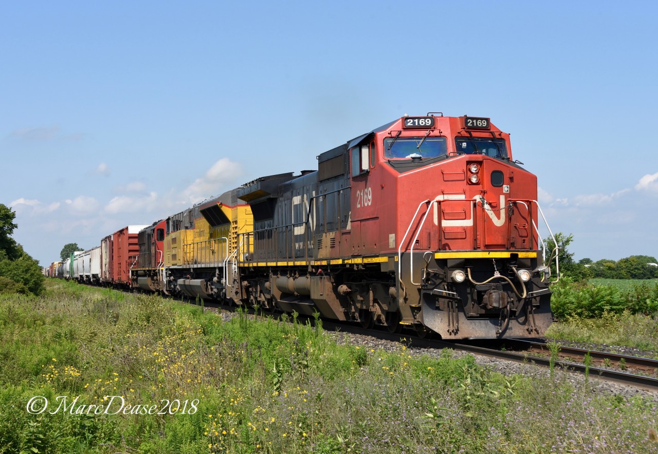 CN 394 lead by CN 2306 with trailing units ElectroMotive DEMO 1606 and IC 1008 head east bound out of Sarnia at Fairweather Sideroad.