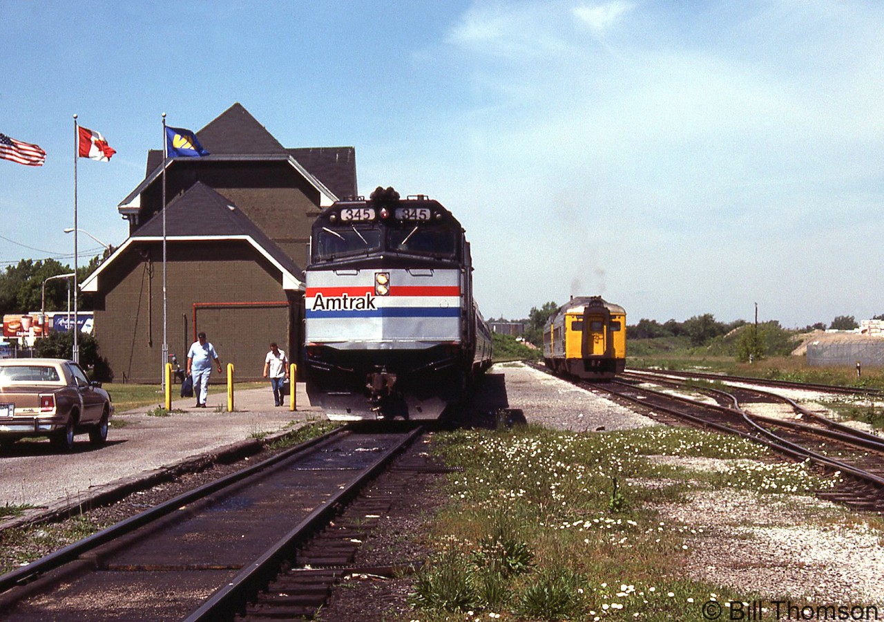 Amtrak F40PH 345 arrives with the US-bound "Maple Leaf" from Toronto at VIA's Niagara Falls station, while a pair of VIA RDC's wait on the adjacent track to depart the station for Toronto.