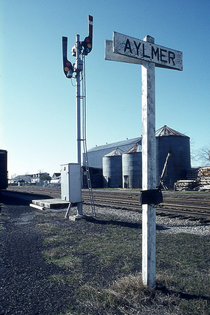 It has been more than 42 years since I pulled in at Aylmer checking for a station. And I did not find one. But I cannot remember whether there was a modular or a trailer in place of it. There had to be some sort of 'office' there, since there was this electric motor controlled train order signal in place. Note behind it the platform for the Operator to hoop up train orders, and attached to the signal base is the case housing relays and batteries. I cannot seem to recall something of this sort anywhere else I visited back then, but there must have been a few.
