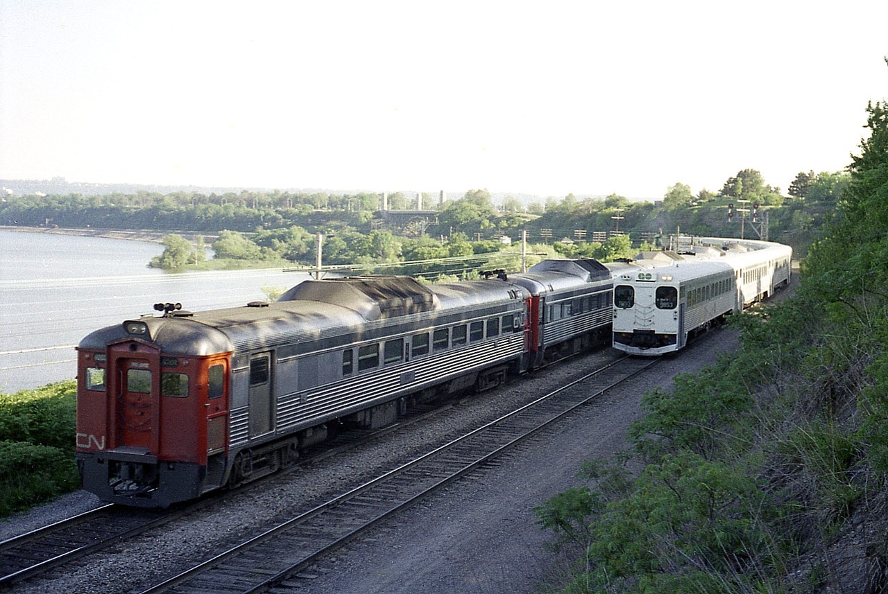 It is getting late on a mild evening and the sun is setting. For once I get sunshine but end up shooting in shadows.  This scene is between Bayview Jct (behind me) and Hamilton Jct ( the curve) and dinner-hour CN Budd Cars and GO train passing.  Cab car number is 9853.