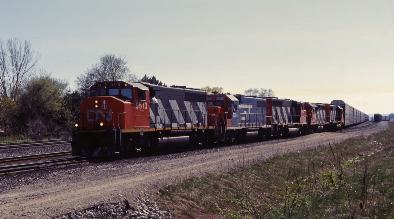 An eastbound works Aldershot Yard with an interesting consist of CN GP40-2LW 9513, GTW GP38AC 6204, GP40-2LW 9504, GP40 9312, and an unidentified SD40. At this time, more CN units were being used on GTW and CV lines, so a number of former DT&I GP38AC units were regularly used as trailing units on CN trains.