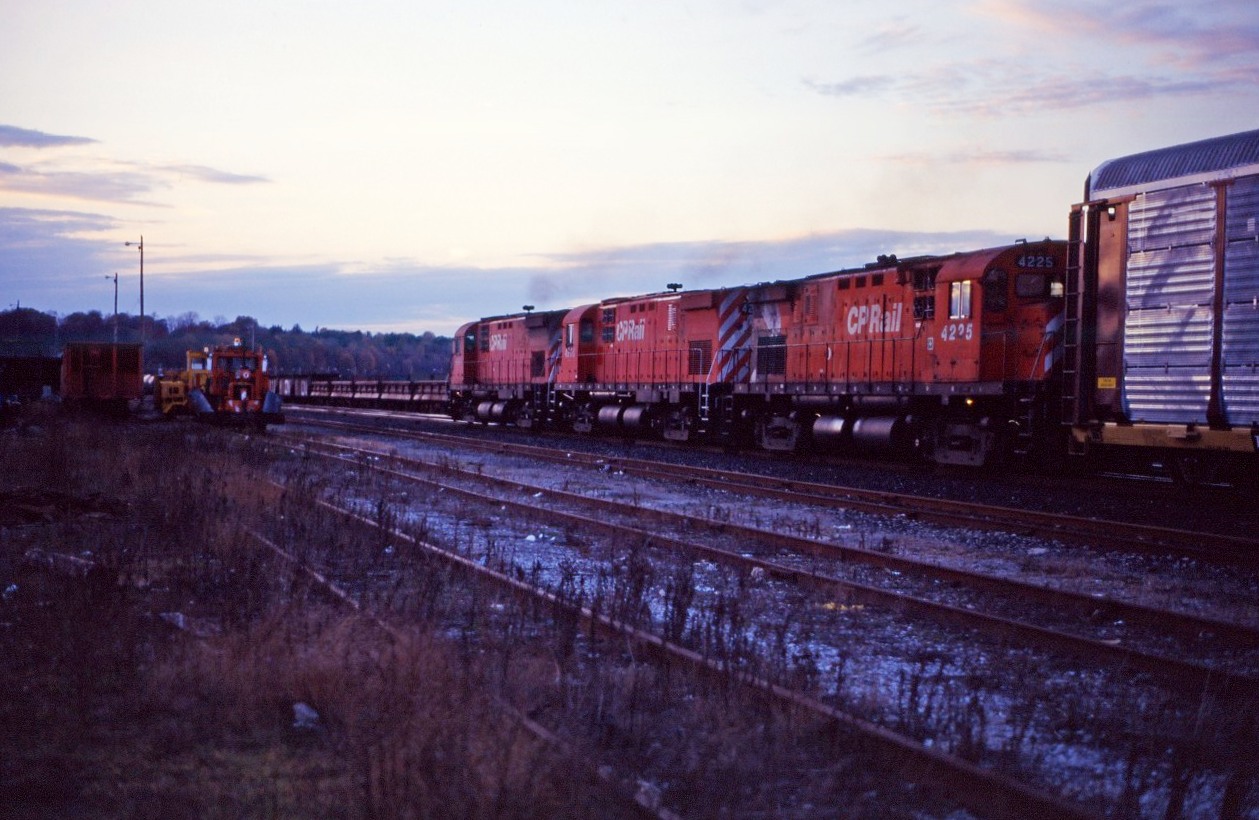 Prior to the opening of the GO Centre in Hamilton and transfer of commuter train service to the former TH&B station,a new track configuration was implemented at Hamilton Jct and the Hunter Street tunnel was modified to accomodate bi-level coaches. During some of these work blocks, CP freight traffic was detoured over CN's Grimsby sub.

Here we see an eastbound CP freight behind a trio of C424s passing through CN's Hamilton Yard at dusk in October 1994.